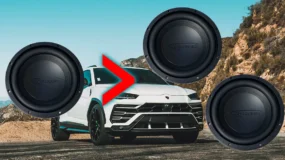 A white vehicle with three car audio speakers in front of it