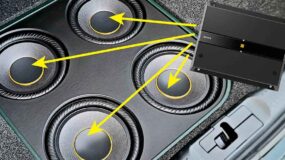 An amplifier with arrows pointing outwards towards four speakers