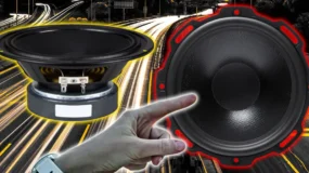 Two speakers, one on the left highlighted in yellow and one of the right highlighted in red. A man's had is pointing to the speaker on the right