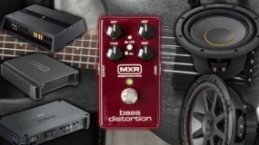 A picture of three amplifiers, two speakers, and a bass distortion control on top of a guitar