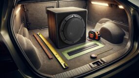 A subwoofer, and various tape measures in the trunk of a vehicle